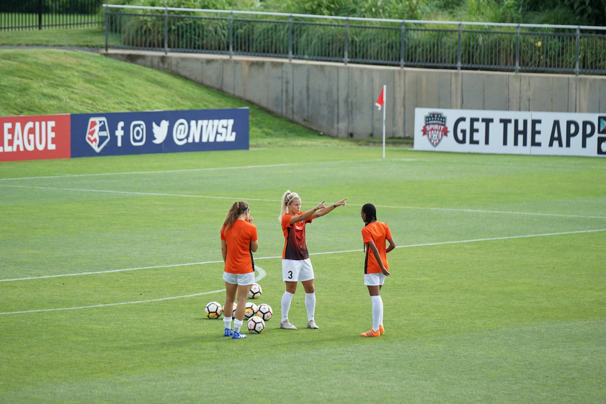 photo of woman standing on soccer field