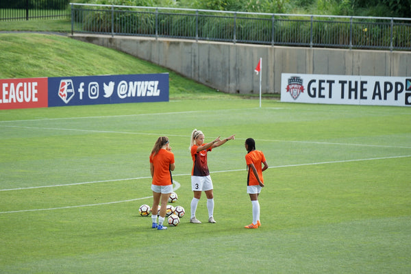 photo of woman standing on soccer field