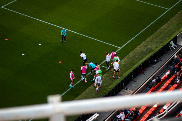 a group of people standing on top of a soccer field