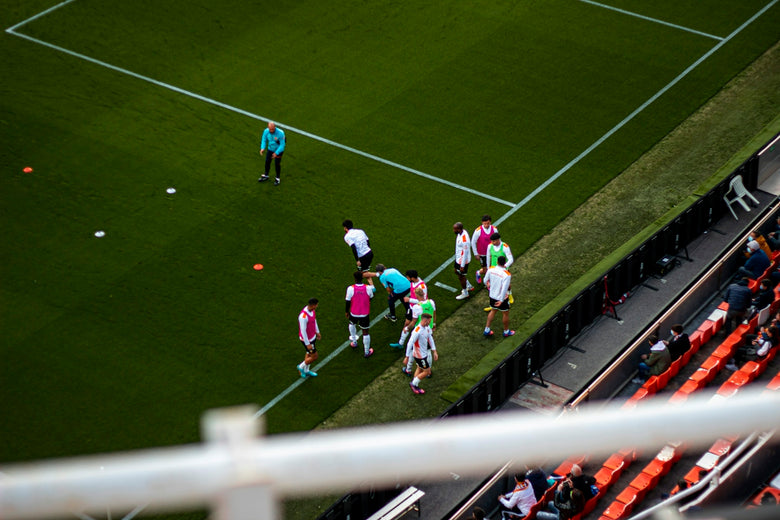 a group of people standing on top of a soccer field