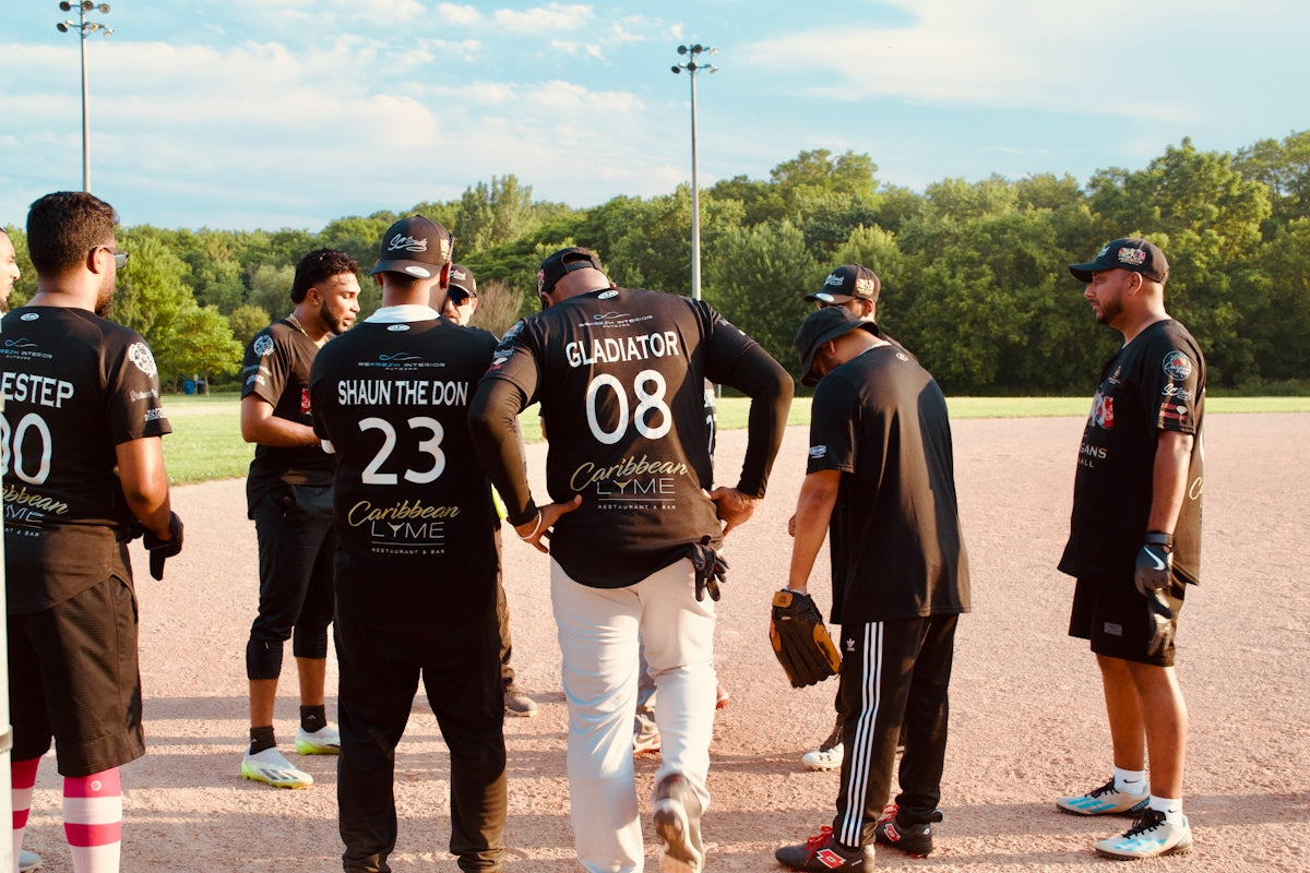 A softball team huddles on the field.
