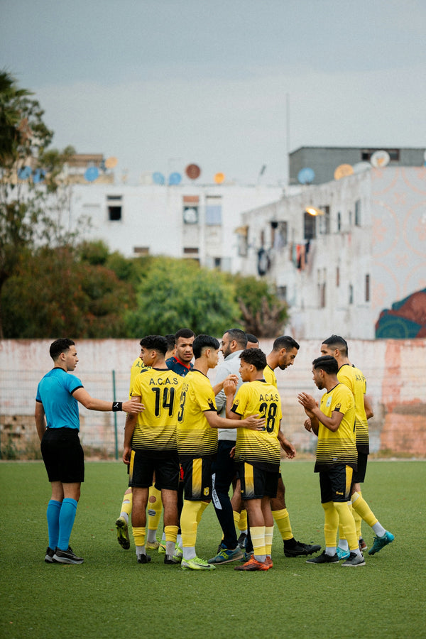 Soccer team huddles with referee before a match