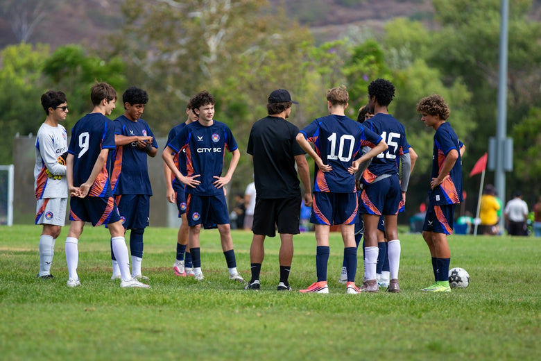 Youth soccer team listens to their coach on the field